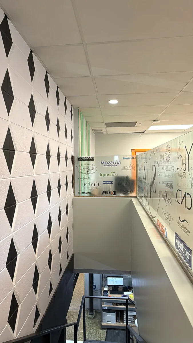 Finished stair and graphic wall connecting the showroom to an office area.