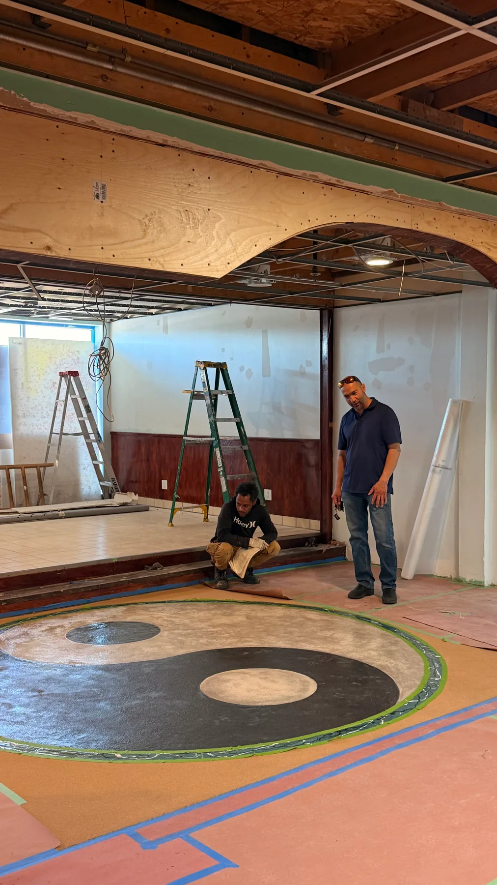 Kaveh speaking with a tradesperson inside a renovation project.